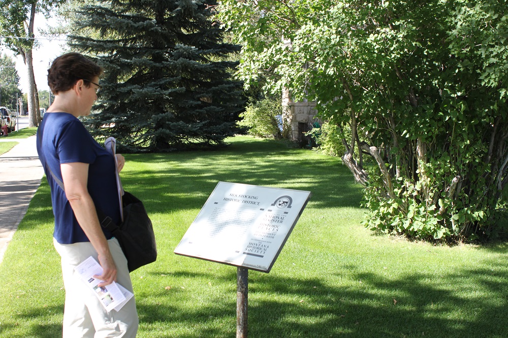 View of abandoned buildings at Elkhorn State Park in MT with National Register sign posted.